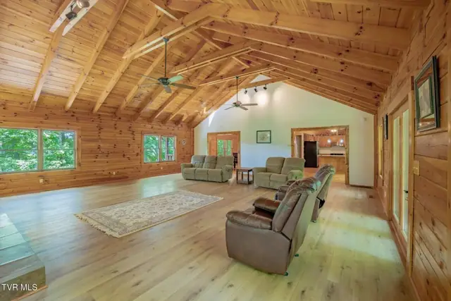 Great room with vaulted wood ceiling and windows on three sides