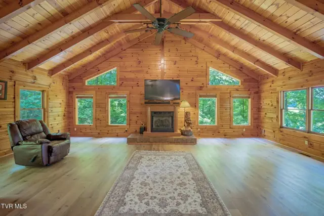Great room with vaulted wood ceiling and windows on three sides